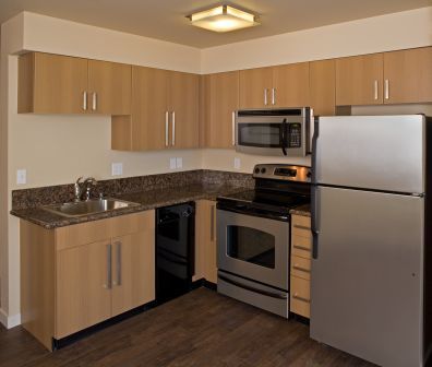 Studio kitchen with granite counters and stainless steel appliances